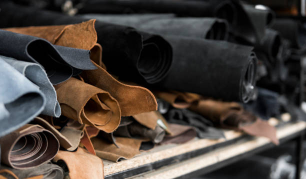 Different pieces of leather in a rolls. The pieces of the colored leathers. Rolls of natural brown and black and other leather. Raw materials for manufacture of bags, shoes, clothing and accessories